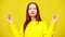 Middle shot of slim cute redhead woman meditating at yellow background. Portrait of calm Caucasian lady eliminating