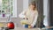 Middle shot of slim gorgeous young woman pouring fruit smoothie in glass and drinking healthful vitamin drink. Portrait