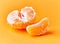 Middle and slice peeled tangerine over yellow background