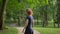 Middle view of young beautiful girl, unfolding into the camera in the park