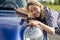 Middle woman driver embracing hood of car after detailing, polishing. Car insurance advertisement