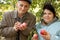 Middleaged couple stand under tree and hold apples