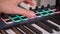 Midi keys on the table with neon lights. Closeup of male hands composing music using midi controller