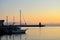 Midnight sunset to the sea in the harbor in Alesund, Norway. Silhouettes of houses, piers, boats and lighthouse at midnight on the