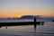 Midnight sunset to the sea in the harbor in Alesund, Norway. Silhouettes of houses, piers, boats and lighthouse at midnight on the