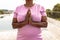 Midsection of african american senior woman meditating in prayer position while standing in yard