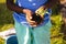 Midsection of biracial boy holding compost and sapling while standing in yard