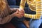 Midsection of biracial lesbian couple holding hands sitting on couch at home