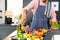 Midsection of biracial man wearing apron cooking dinner, pouring vegetables in kitchen