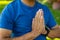 Midsection of biracial senior man meditating in prayer position while sitting in yard