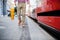 Midsection of blind man with white cane getting on public transport in city.