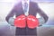 Midsection of businessman wearing red boxing gloves