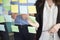 Midsection Of Businesswoman Sticking Note While Standing By Executive