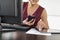 Midsection Of Businesswoman Using Technologies At Desk