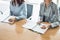 Midsection of businesswomen with books at table in office