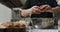 Midsection of caucasian female chef breaking eggs into metal bowl