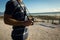 Midsection of caucasian man on the beach holding camera