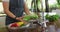 Midsection of caucasian pregnant woman wearing apron, washing vegetables in kitchen