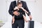 Midsection of father carrying baby while holding briefcase