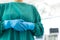 Midsection of female surgeon in blue surgical gloves and green gown, with copy space