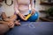 Midsection of female therapist showing electrical muscle stimulation machine to boy sitting on bed