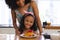 Midsection of happy biracial mother and daughter with tempting pancakes on table at home