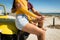 Midsection of happy caucasian couple sitting on beach buggy by the sea holding hands