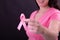 Midsection of happy caucasian woman in pink tshirt holding pink ribbon