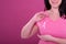 Midsection of happy caucasian woman in pink tshirt with ribbon gesturing