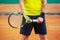 Midsection of male tennis player holding the racket