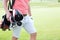 Midsection of man carrying golf club bag at course