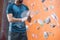 Midsection of man dusting powder by climbing wall in crossfit gym