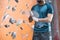 Midsection of man dusting powder by climbing wall in crossfit gym