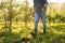 A midsection of mature farmer walking outdoors in orchard. Copy space.