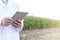 Midsection of mature scientist using digital tablet at farm