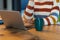 Midsection of mixed race businesswoman sitting at conference table with laptop