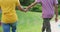 Midsection of mixed race gay male couple holding hands walking in garden