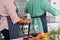 Midsection of multiracial senior couple wearing aprons while standing in kitchen at home