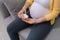 Midsection of pregnant woman pouring pills in hand from bottle at home