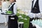 Midsection of professional waiters in uniform serving wine and snacks during buffet catering party, festive event or