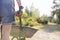 Midsection rear view of female gardener pushing wheelbarrow at plant nursery