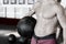 Midsection Of Shirtless Trainer With Medicine Ball