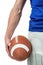 Midsection of sports player holding ball