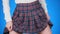 Midsection of teenage girl, cheat sheet written on hips hidden under a skirt. 4k, close-up, blue background, slow-motion