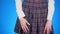 Midsection of teenage girl, cheat sheet written on hips hidden under a skirt. 4k, close-up, blue background, slow-motion