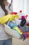 Midsection of woman carrying basket of cleaning supplies at home