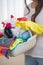 Midsection of woman carrying basket of cleaning supplies at home