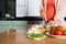 Midsection Of Woman Cutting Vegetables At Kitchen Counter