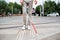 Midsection of young blind man with white cane walking across the street in city.