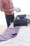 Midsection of young businessman unpacking luggage in hotel room